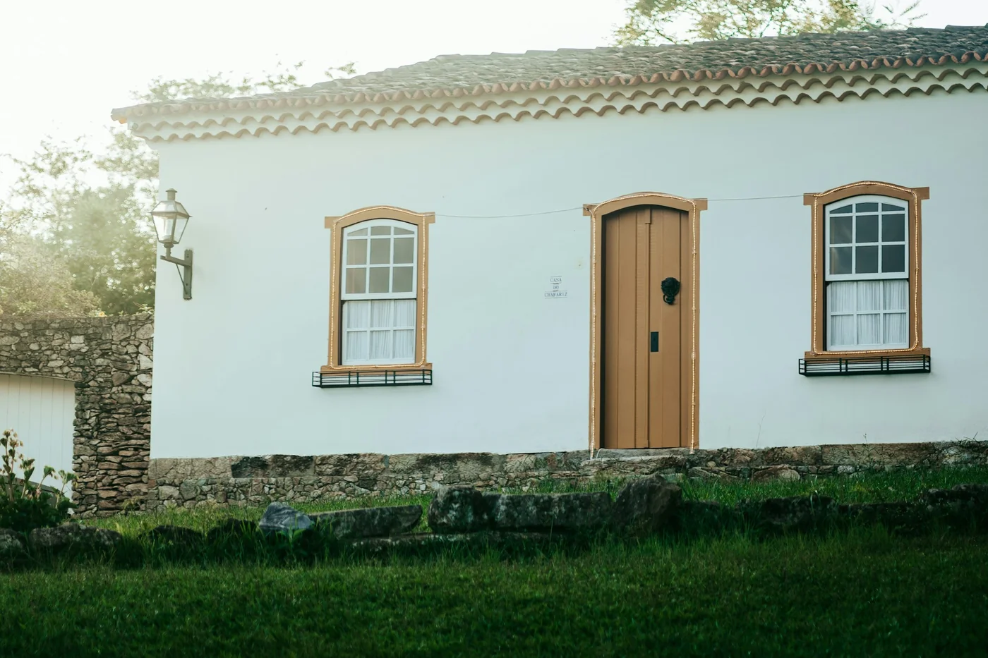 Fachada de casa brasileira com telhado de cerâmica e porta de madeira.