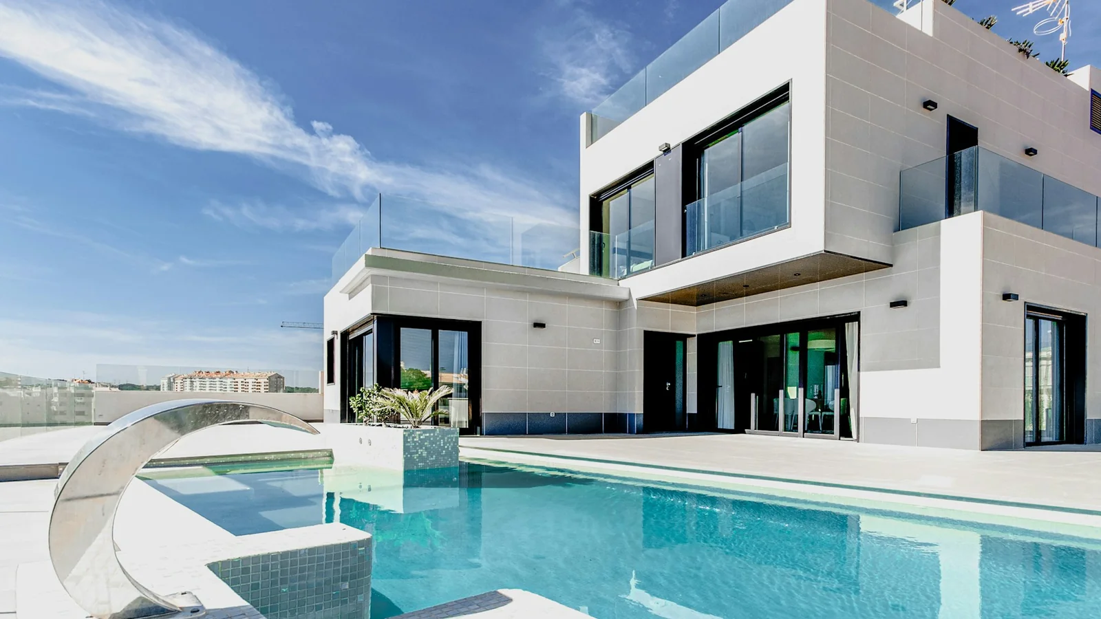 Residência branca de arquitetura contemporânea com jardim e piscina.