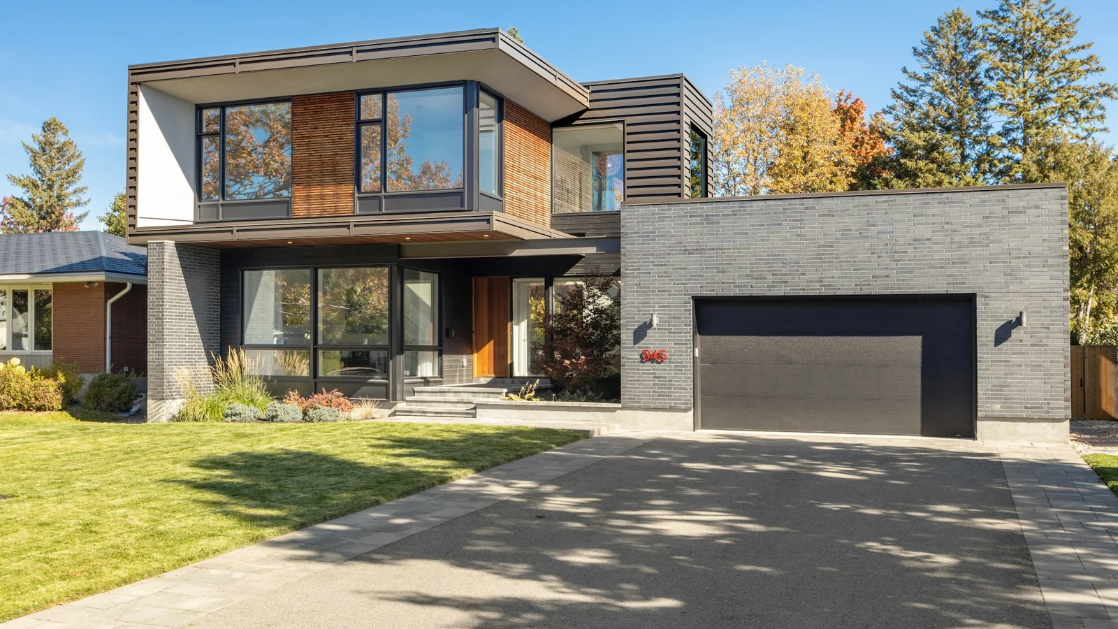 Fachada de residência contemporânea com acesso pavimentado e jardim.